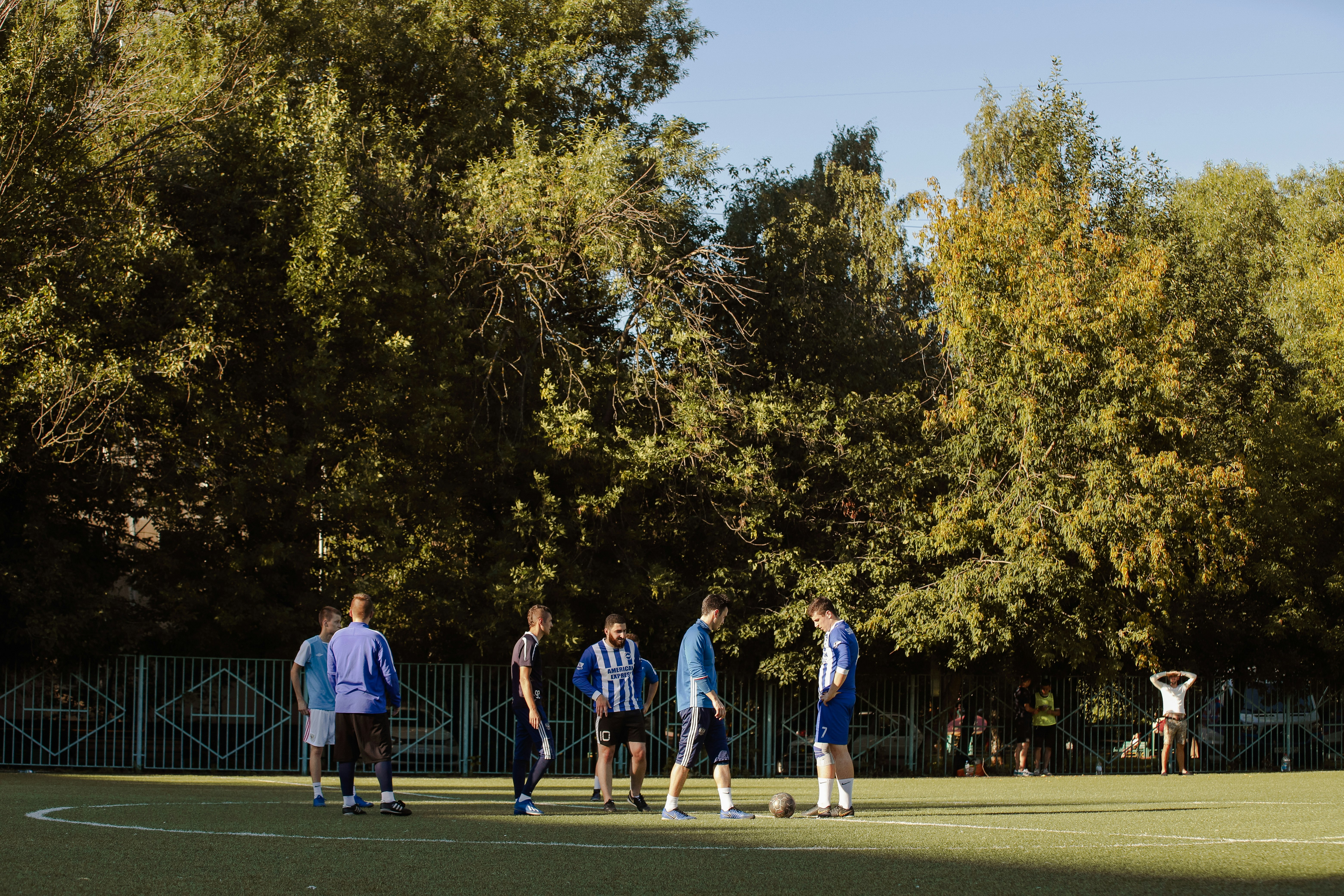 people playing basketball on green grass field during daytime